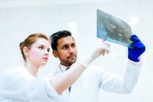 Multiracial dental team checking teeth x ray of patient. Dental clinic concept